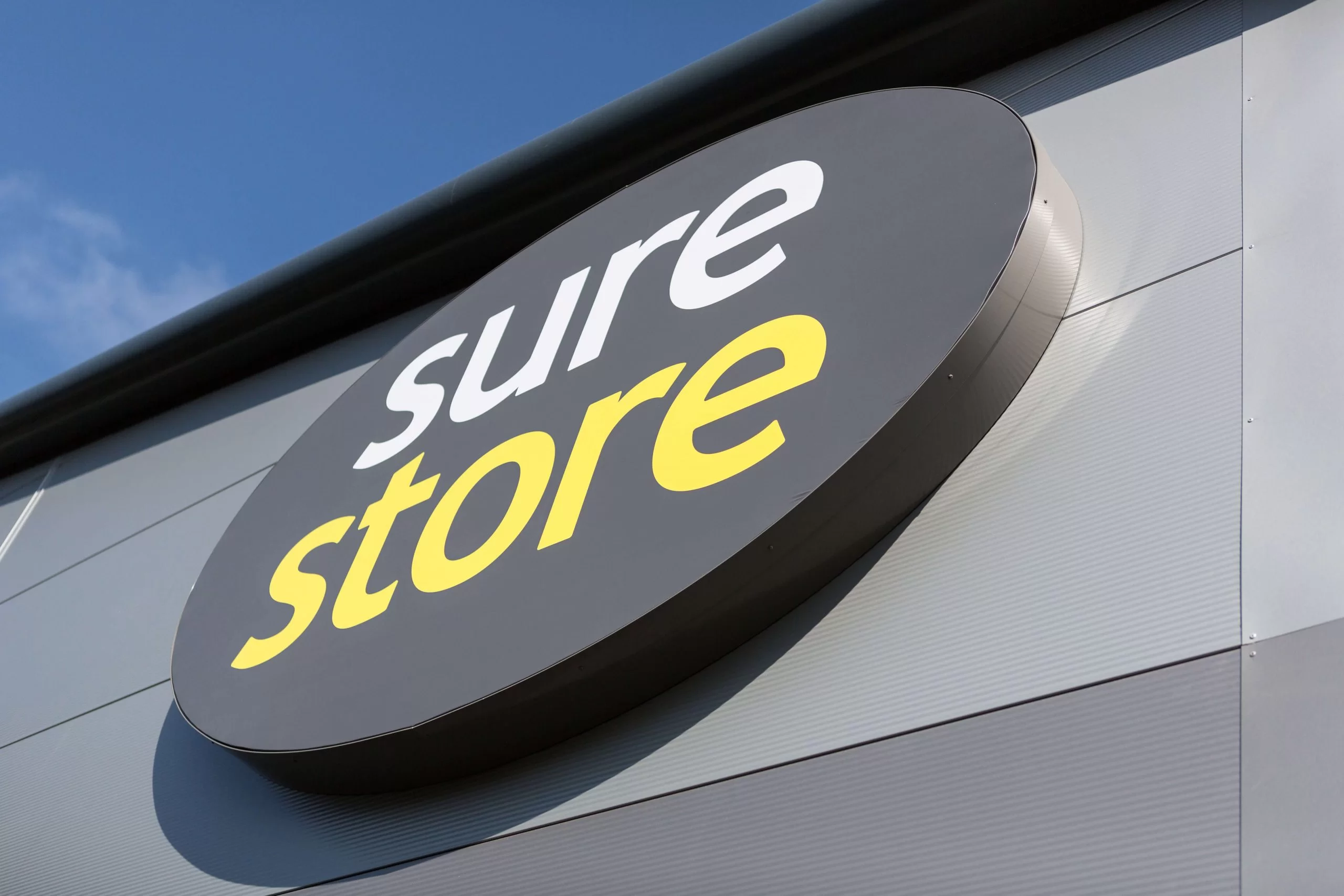 Sure Store sign against blue sky