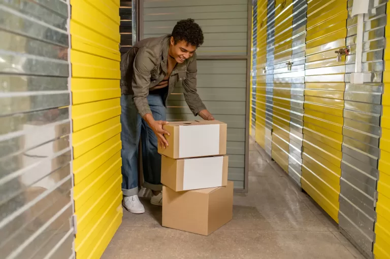young dark haired man with boxes in stock house storage